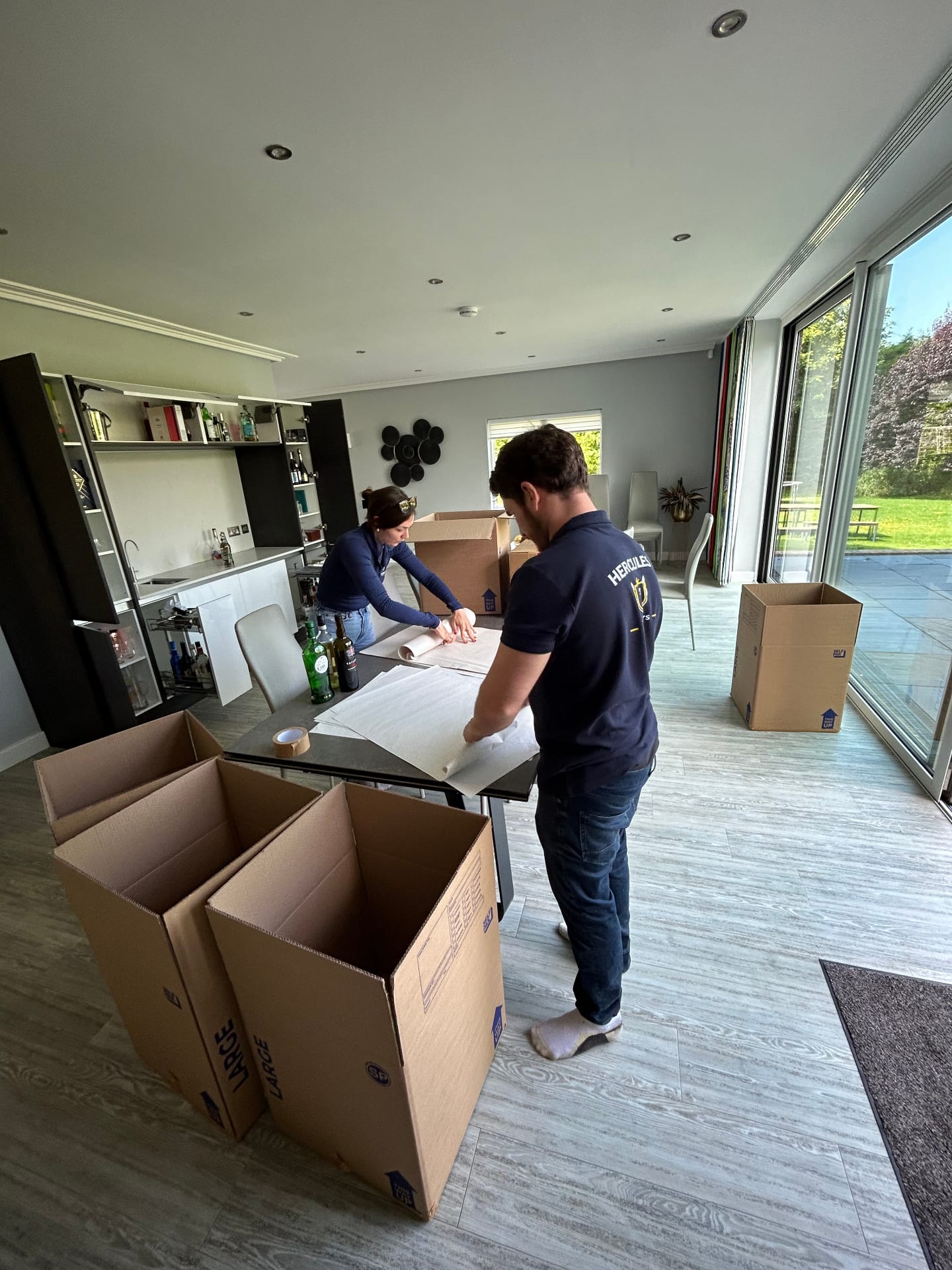 Hercules packers wrapping glassware and dishes for a Cambridge home move